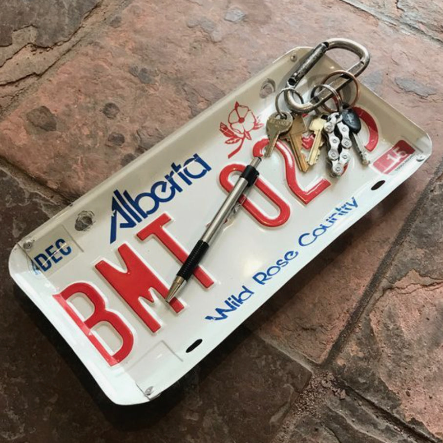 Tray for holding keys or coins that is made from a recycled Alberta license plate. Edges are bent and riveted in four corners to make its tray shape.