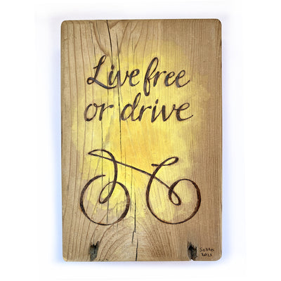 wood burned, hand painted art of bicycle with quote "Live free or drive"